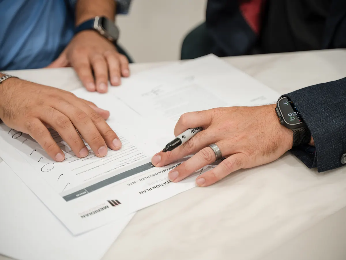 A Meridian consultant and client reviewing an implementation plan together at a table